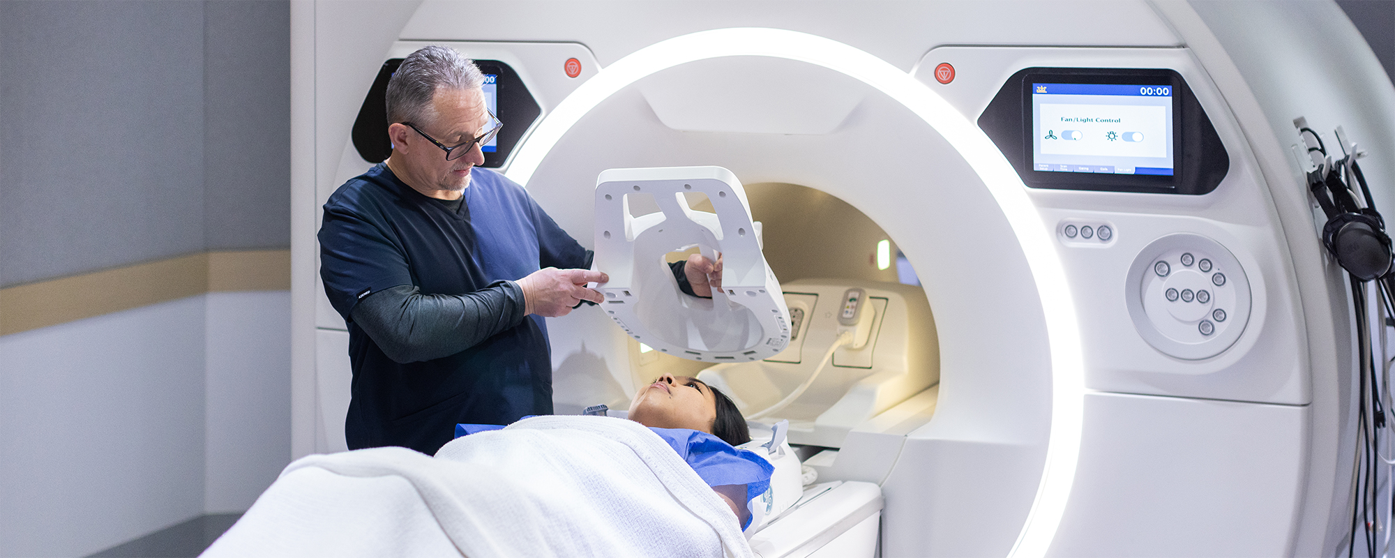 Radiologist Preparing Female Patient For MRI Exam